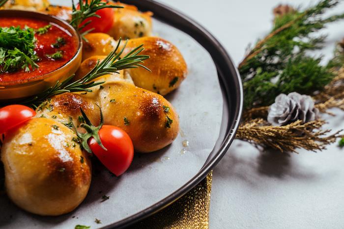 ortasında salsa, üstte kişniş ve tereyağı ve biberiye ve kiraz domates dekorasyonu ile Noel menüsü için mozzarella ekmeği nasıl yapılır