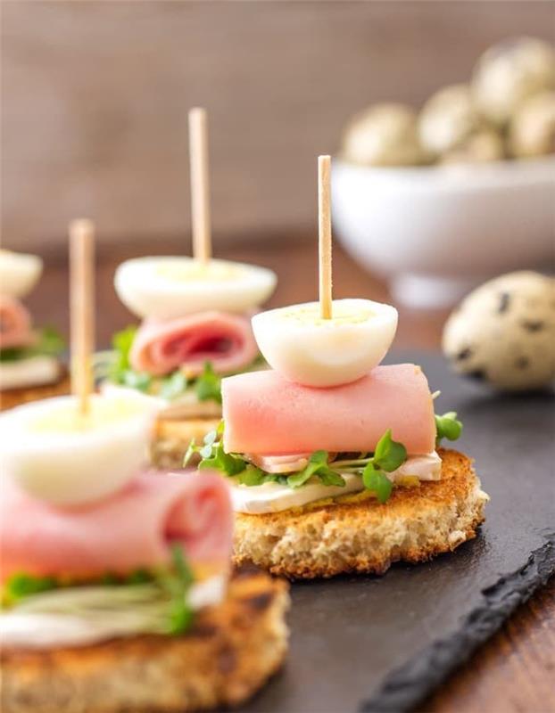 skrebučių skrebučiai su ožkos sūriu, kumpiu, kiaušiniu ir šviežiomis žolelėmis ant skrudintos duonos, lengvai pagaminamas tapas receptas, aperityvo vakarienės iešmas