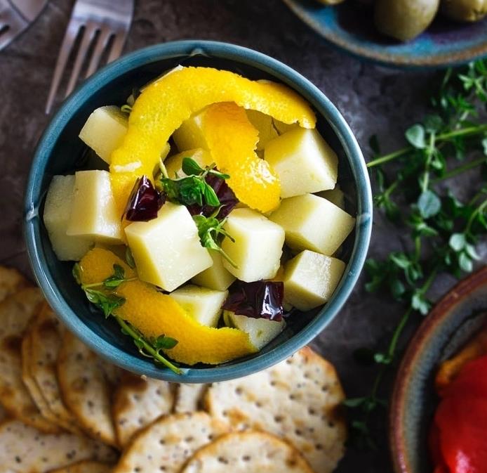 enostavni recepti za tapas, kocke sira manchego z mešanico olivnega olja, timijana, rožmarina, rdeče paprike in pomarančne lupine