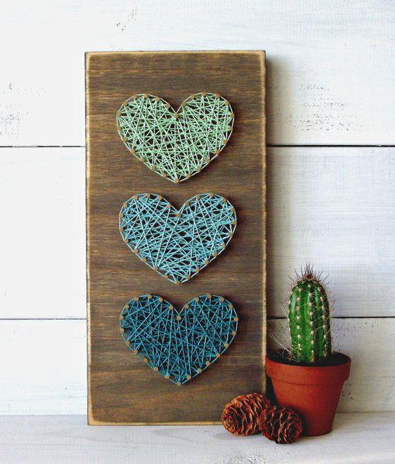 Üç kalp şekliyle süslenmiş, çivi ve mavinin farklı tonlarında iple yapılmış dikdörtgen ahşap tahta, kolay sanatlar ve el sanatları, yakındaki kaktüs bitkisi