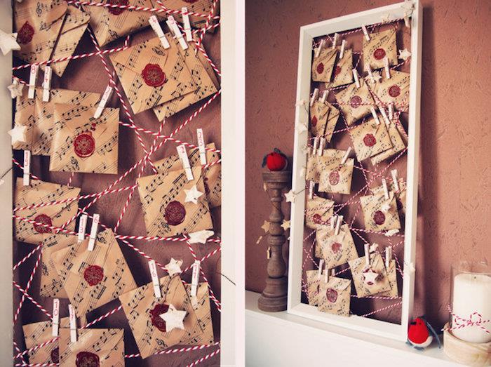 medinis rėmas su mažais maišeliais su muzikinių natų raštu ant raudonų ir baltų siūlų, kabančių ant medinių drabužių segtukų