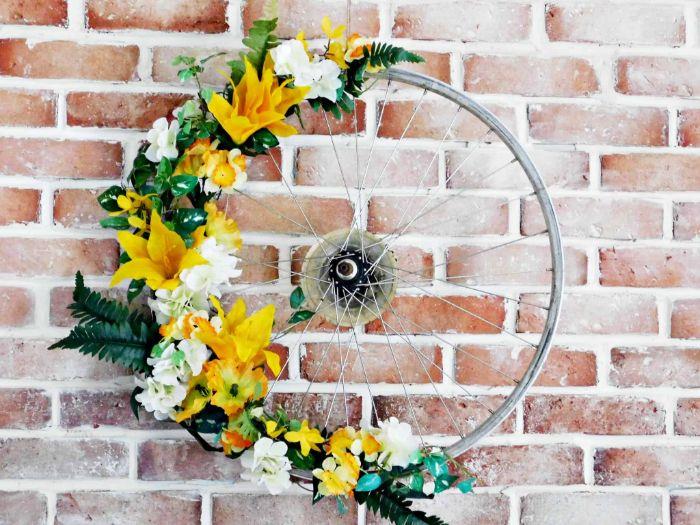 kolo za recikliranje, okrašeno z zunanjimi stenskimi dekoracijami iz rumenega in belega cvetja, da ga naredite sami