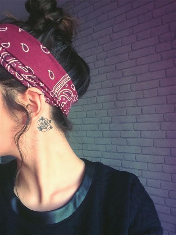 rožė už ausies tatuiruotės, raudona bandana ant rudų plaukų, netvarkinga bandelė, maža saulėgrąžų tatuiruotė