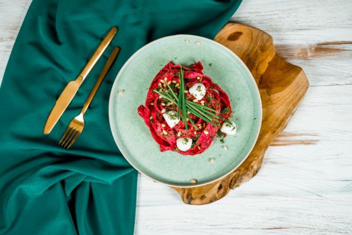 eleganten obrok iz testenin iz rdeče pese z majhnimi kroglicami mocarele v nebesno modri plošči ideje za obrok za noč čarovnic