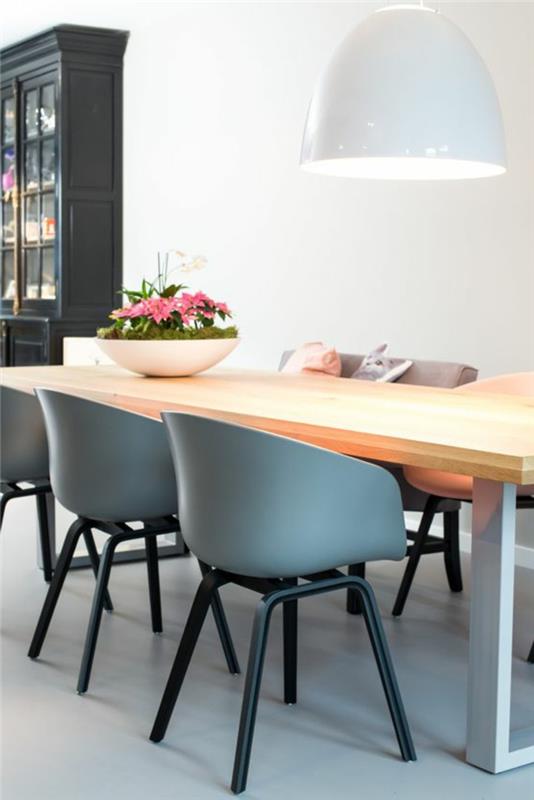 prenoviti svojo kuhinjo, trije modri plastični naslanjači, tla z belimi sijajnimi ploščicami, pravokotna miza iz svetlega lesa z belimi nogami, kuhinjska omara v starem slogu v črni barvi