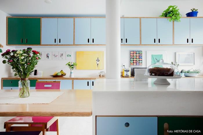 perdažyti virtuvės spintelę, žalios ir pastelinės mėlynos spalvos perdažytas spinteles, centrinę salą ir medinį stalą, medinį stalviršį ir piešinius dekoruotą apšvietimą