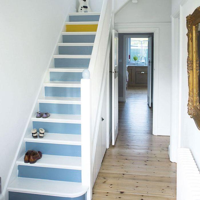 modra siva in rumena barva stopnišč, nanesena na dvižne vodnike, da razbije monotonijo bele barve na hodniku
