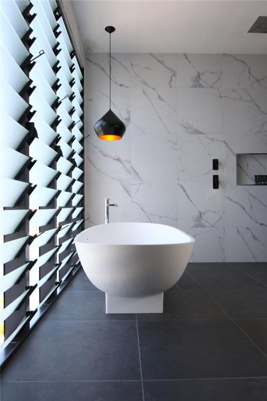 sodobna kopalniška postavitev s stenami iz belega marmorja in tla iz keramičnih ploščic iz oglja