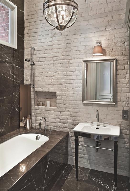 sodoben dekor za kopalnico s kadjo z belimi opečnimi stenami in črnimi ploščicami s kadjo in belim umivalnikom