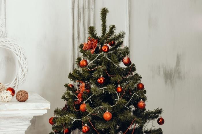 Kalėdų eglutės dekoravimo idėja su raudonais ornamentais ir šviesiomis girliandomis, balta svetainės puošmena Kalėdoms su dirbtine eglute