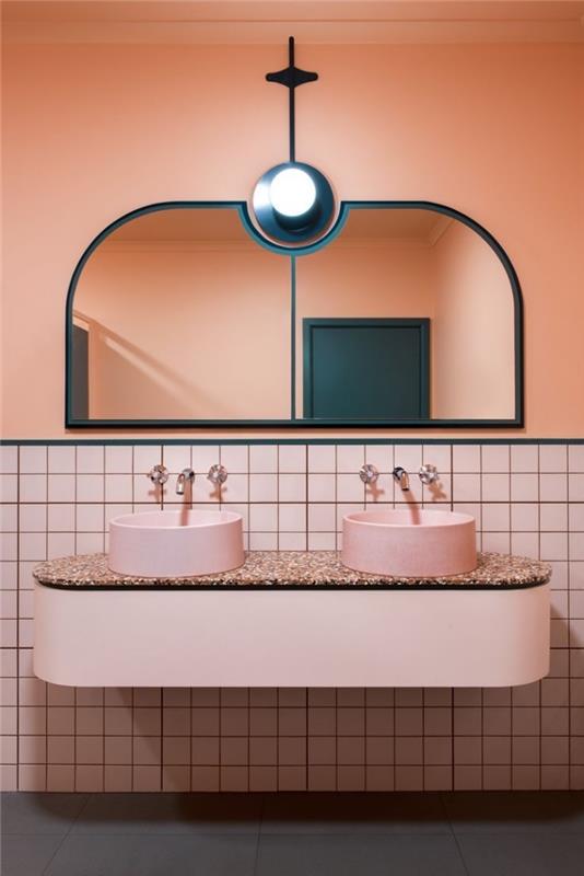 duvarı yarıya kadar süsleyen pembe mozaik duvar karosu, mermer lavabo tablalı yuvarlak hatlı asma ikili lavabo dolabı