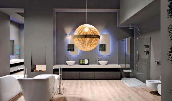 sodobna kopalniška razsvetljava s sivimi stenami in svetlim lesenim podom, belo kopalniško pohištvo in oprema