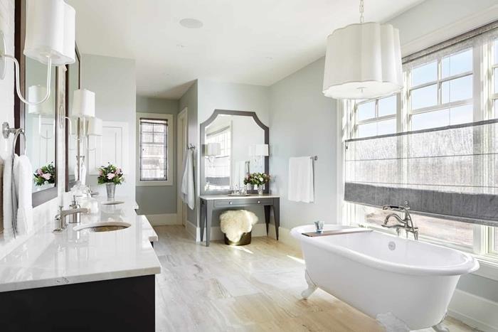 seno stiliaus vonios akmens plytelių grindys su laisvai stovinčiu vonios veidrodžiu šviesiai pilka spintelė