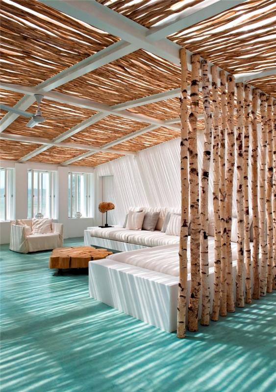 egzotiško stiliaus apdaila su jūrinio stiliaus akcentais, pajūrio svetainė su baltomis sienomis su medine skiriamąja siena