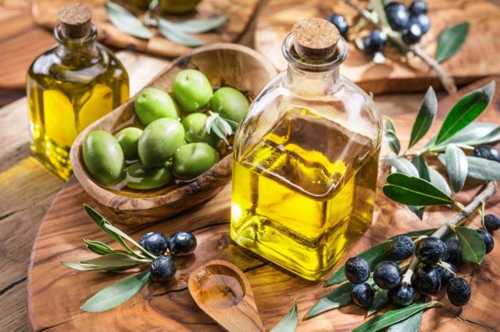 sredozemsko dietno olivno olje v steklenički ob vejici oljke