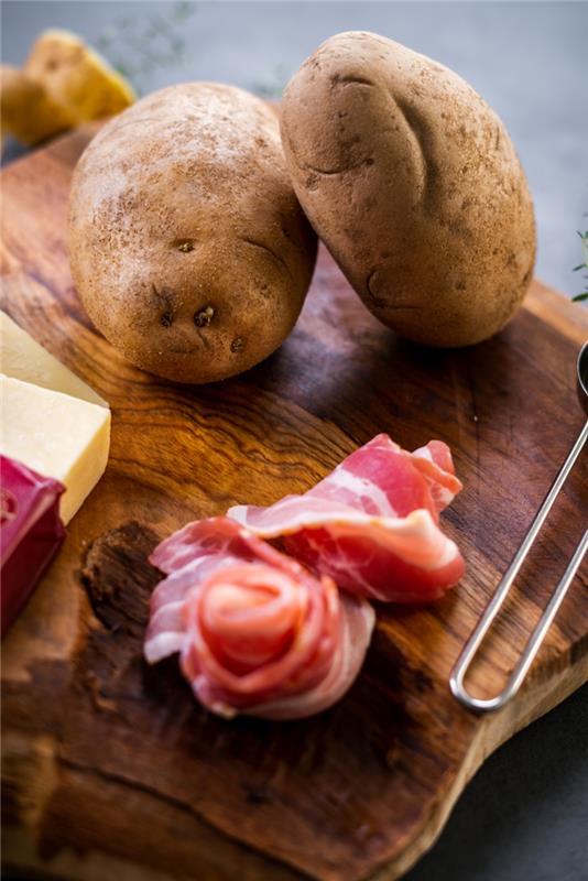 Zaradi krompirja in fette di slanine, riževega s krompirjem, tagliere di legno sestavine sopra