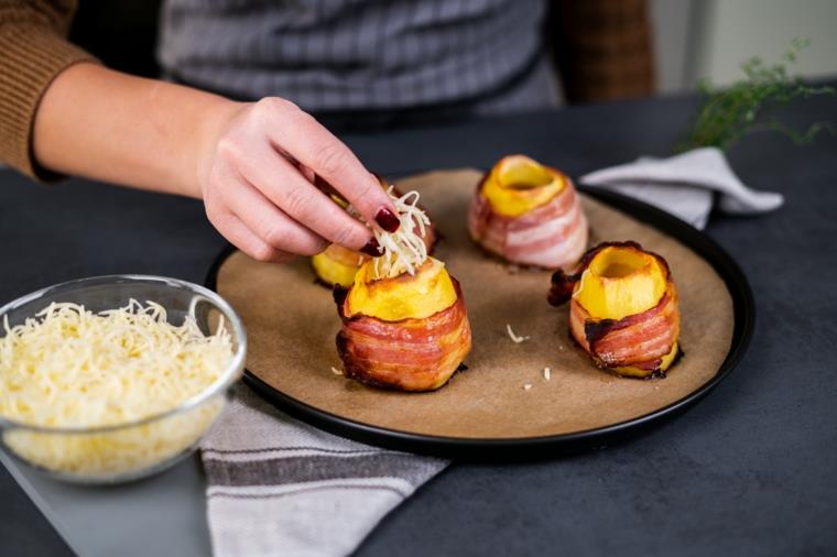 Ricette con uova e krompir, ciotola con formaggio cheddar grattugiato e fette di slanina