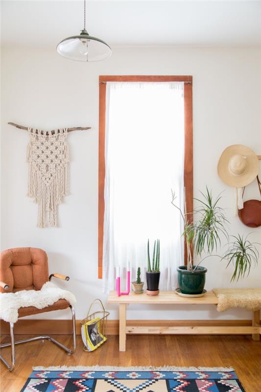 boemsko elegantna dnevna soba z lesenim pohištvom in zelenimi rastlinami, stenski makrame vzorec iz lesene palice in vrvi