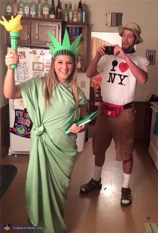 Turistams Niujorke lengva Helovino kostiumo idėja, juokinga pora, Laisvės statula ir turistas fotografuoja