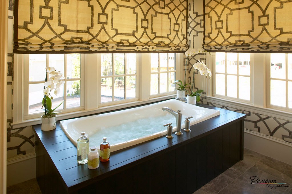 O padrão das cortinas romanas repete o padrão da decoração decorativa das paredes da casa de banho