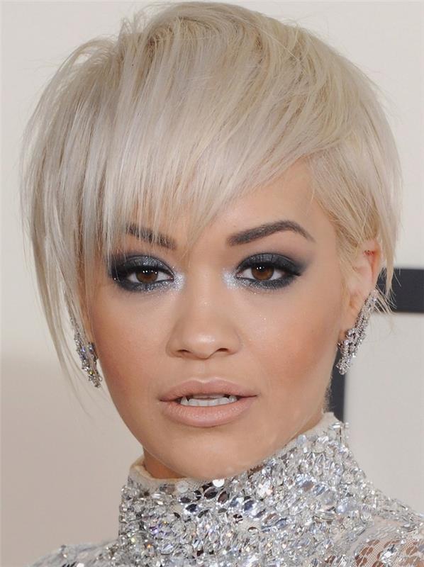 rita ora s kratko ostriženo žensko s spredaj česanimi lasmi, asimetričnimi šiškami, oblečeno obleko