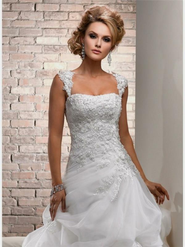 graži vestuvinė suknelė, bohemiška vestuvinė suknelė, įmantri bandelių šukuosena, plytų siena