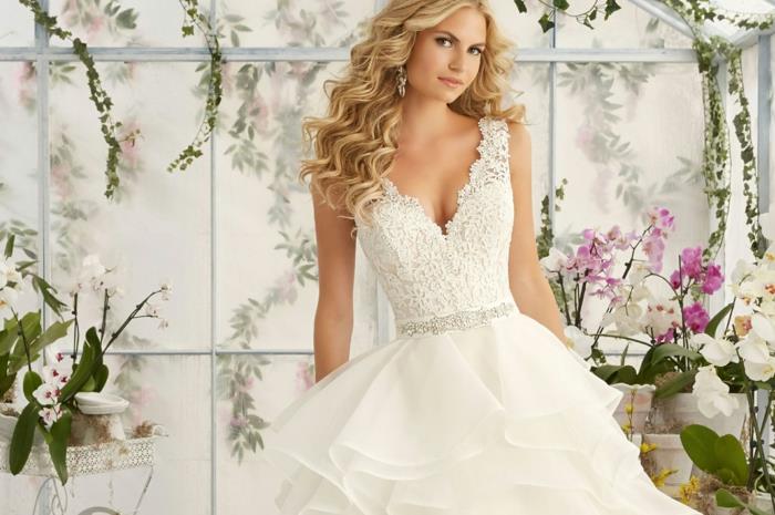 klasikinė suknelė, prigludęs juosmuo, šviesūs garbanoti plaukai, vestuvių lauko puošmena