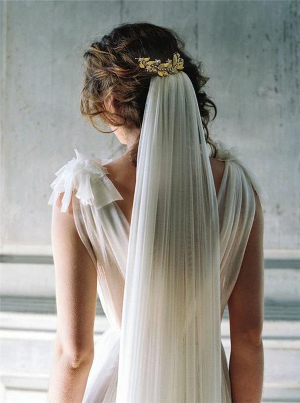 gražus vestuvių aksesuaras, pritvirtintas prie romantiškos šukuosenos, nuotakos šydas, pritvirtintas lauro lapų šukomis