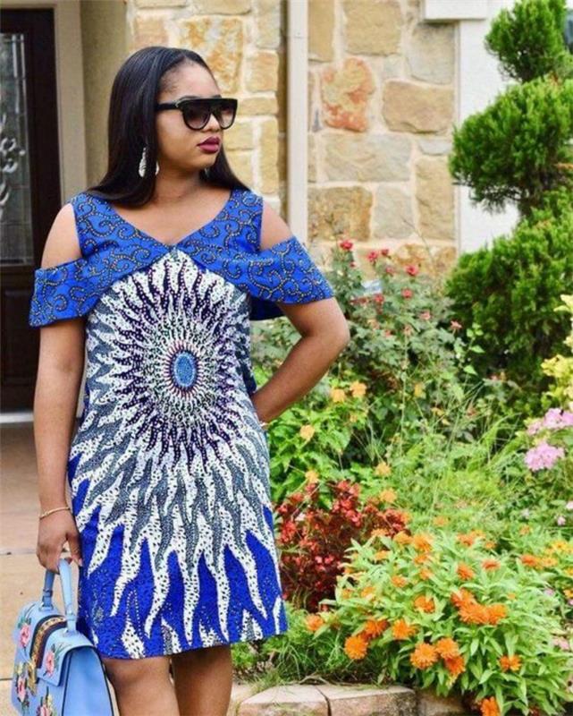 obleka s spuščenimi rameni, afriška moda, velik afriški vzorec, sonce v beli in kraljevsko modri barvi, dolžina nad koleni, torbica v pastelno modri barvi s cvetličnim vezenjem v roza in pastelno modri barvi
