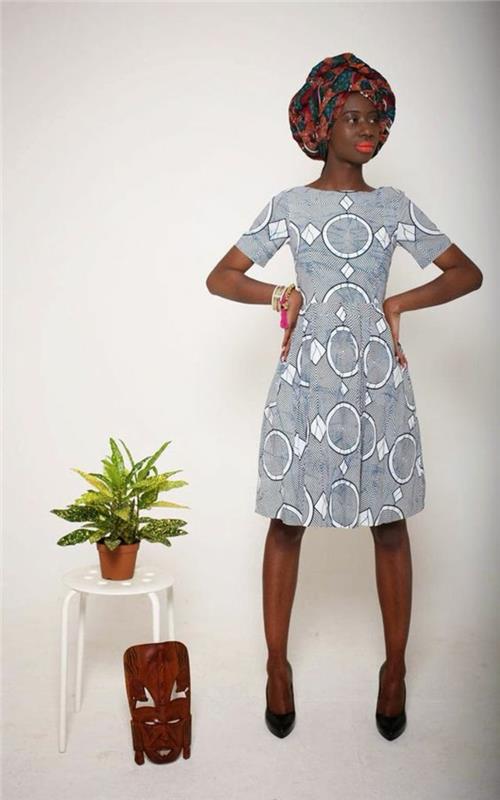 model obleke v biserno sivi barvi, ženska s turbanom v bencinsko modri in rjavi barvi, afriška moda, afriška ženska obleka, ozki kratki rokavi, vzorci belih krogov
