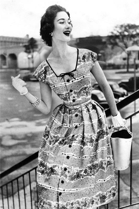 50'lerin modaya uygun gülümseyen kadını, eldivenleri ve büyük saati, düğmeli sevimli elbise