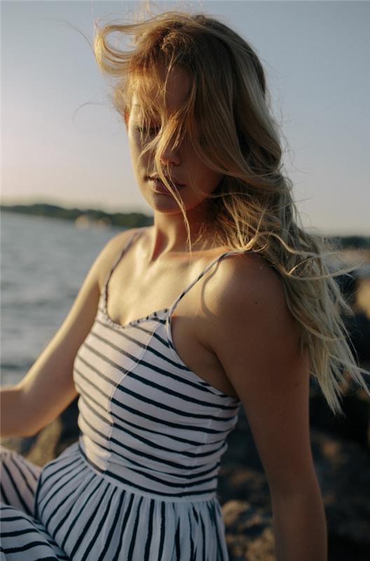 mlada ženska z dolgimi temno blond in karamelno blond ombre lasmi, mornarsko črtasto obleko