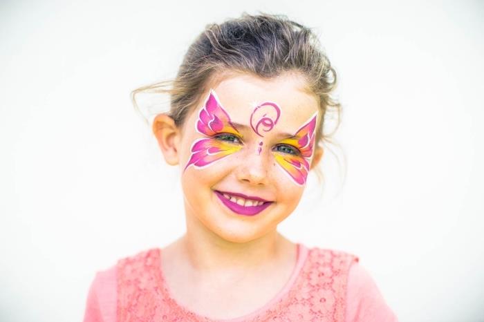 şablon ve pembe ve sarı yüz boyaları kullanılarak yapılan kelebek tasarımlı kız makyaj modeli