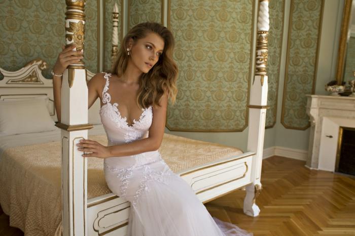 poročna obleka morska deklica, beli čipkasti trakovi, široko odprt V izrez, poročna obleka bodycon, sanjska nevesta, ki sedi na veliki postelji