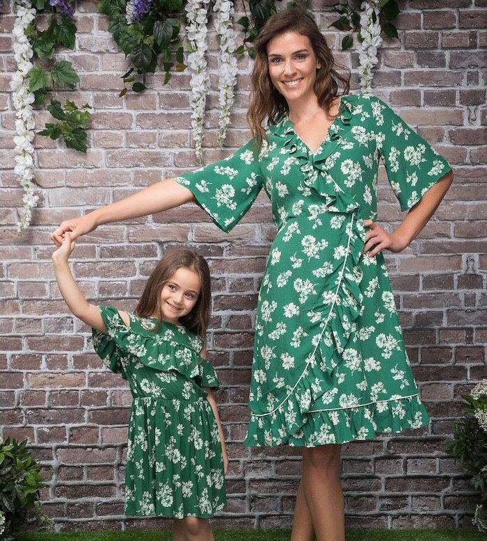Žalią gėlę atitinkanti motinos dukros suknelė, atsitiktinė prašmatni šiuolaikinė moteris ir jos dukra su suknele