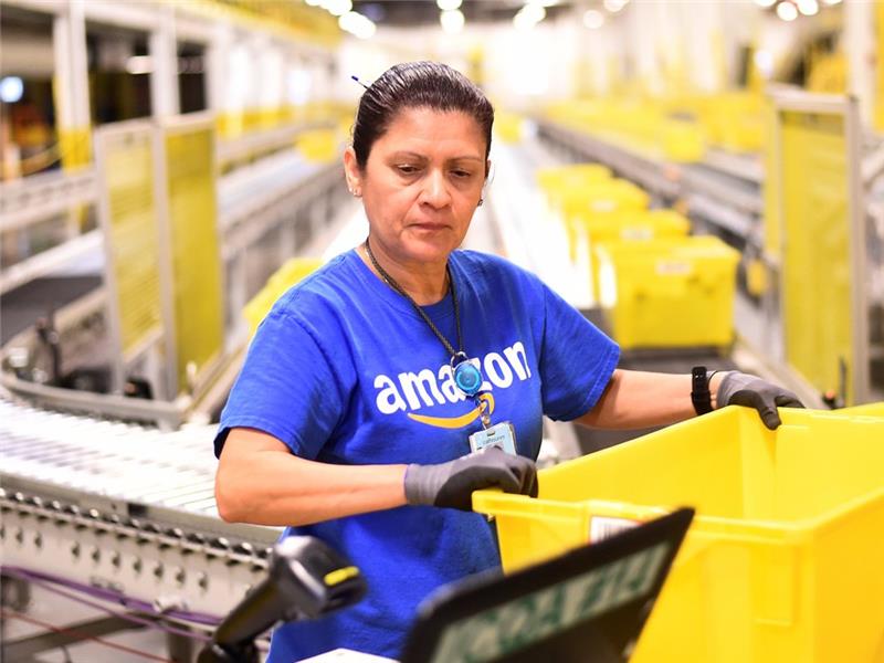 bir siparişin hazırlanmasında bir Amazon çalışanının fotoğrafı, on yıl boyunca bir robot tarafından değiştirilmeyecek bir pozisyon