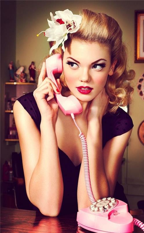 arka muz ve pembe telefon ile makyaj pin up ile retro 50'lerin rockabilly saç modeli ile sarışın kadın