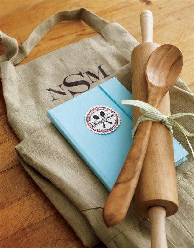 açık mavi yemek tarifi kitabı, ahşap oklava ve tahta kaşık, bir kurdele ile birbirine bağlanmış, yaratıcı hediye fikirleri, büyük çuval bezi