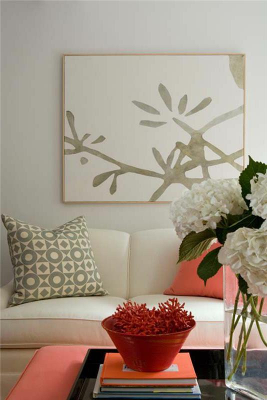koralno rožnati stolček in blazina, svetlo siva stena z abstraktnim slikarstvom