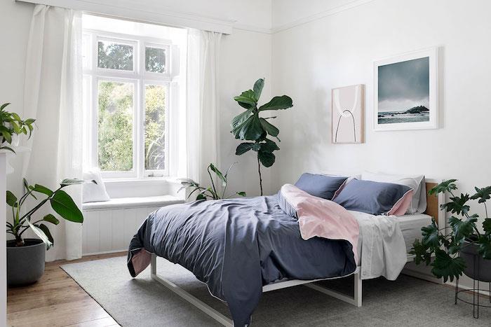Yeşil bitkiler ile çözülmüş beyaz yatak odası, pembe ve mavi keten ile çift kişilik yatak, sevimli dekor bohem şık yatak odası