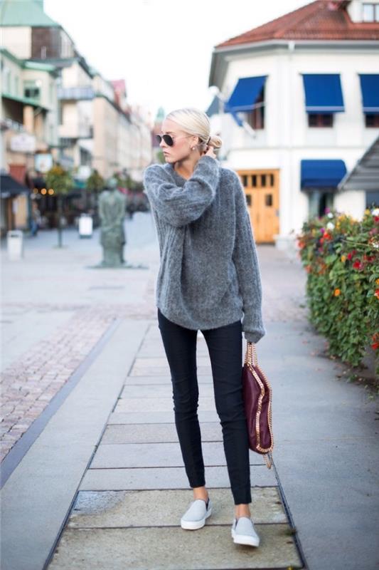atsitiktinė prašmatni moteris atrodo plonomis kelnėmis ir megztiniu, originaliais madingais 2019 2020 metų moteriškų megztinių modeliais
