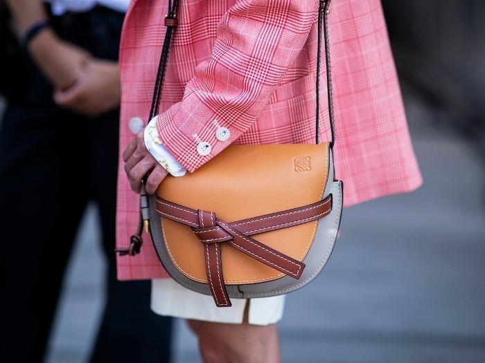 krepšys rudos ir pilkos spalvos, rožinės spalvos kvadratinėje striukėje, trumpas baltas sijonas, originali rankinė