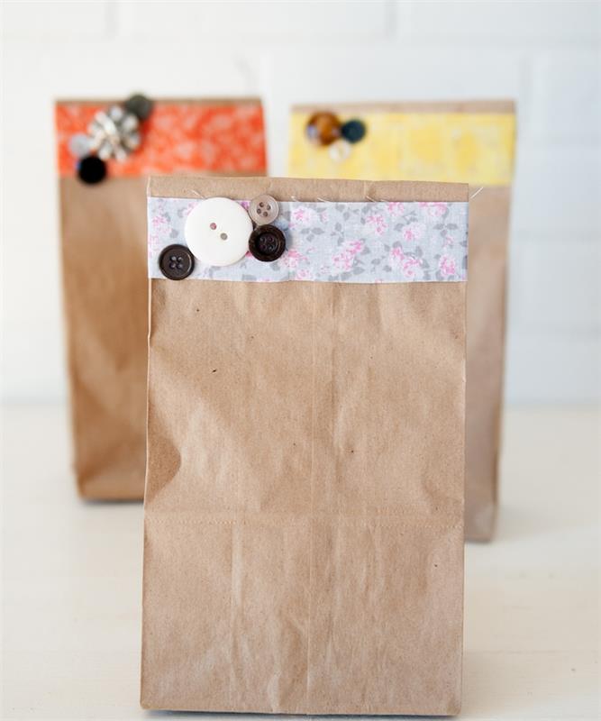 kraft maišelis, dekoruotas audinio juostele su gėlių raštu ir įvairių spalvų sagomis, paprasta pakuotės idėja