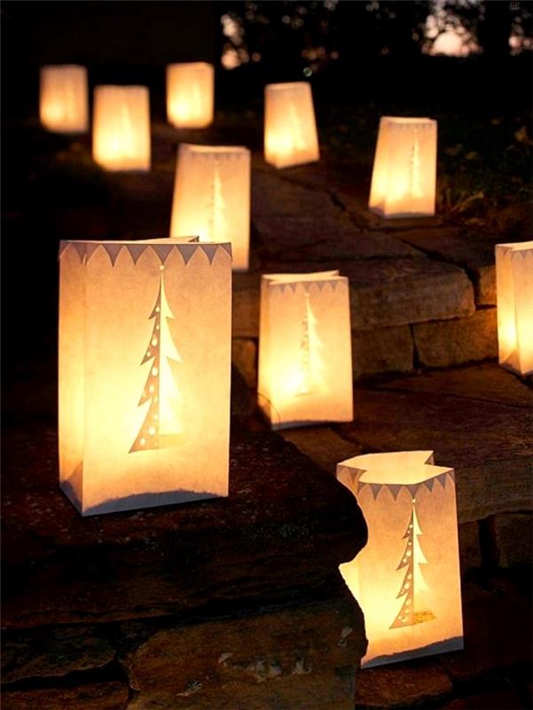 lauko kalėdinis papuošimas popieriniais maišeliais, iškirptais ant akmeninių grindų pastatytomis lemputėmis