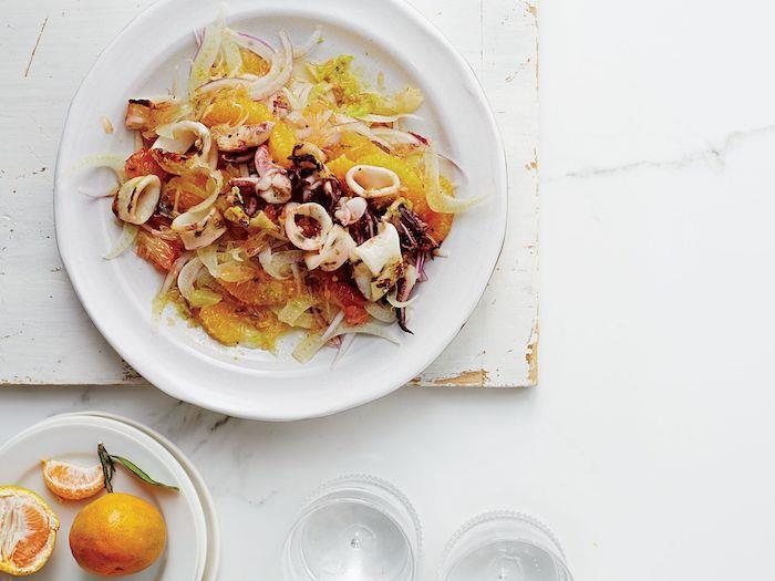 apelsinų salotos su kalmarais ir pankoliais gurmaniškas receptas, patiekiamas ant marmurinio stalo