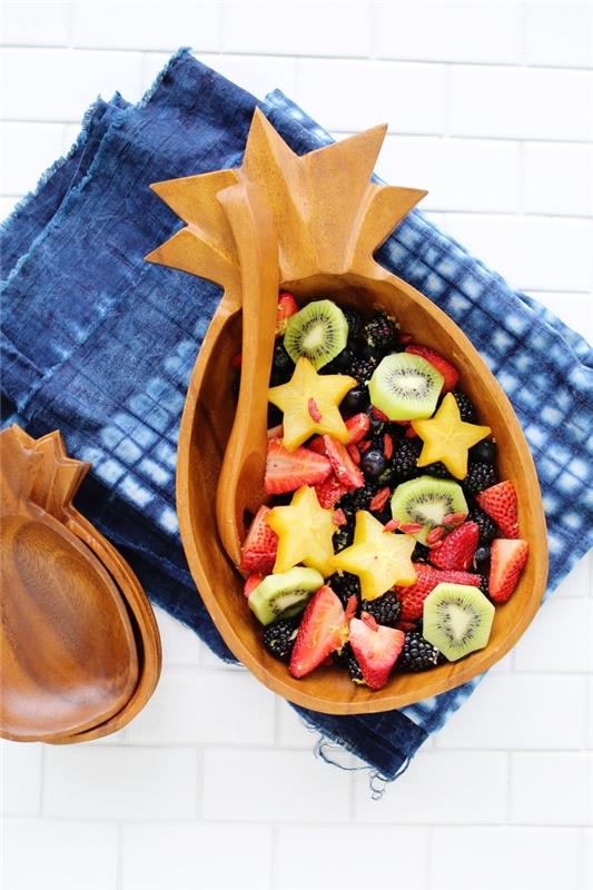 ananas şeklindeki güzel bir kapta servis edilen, yaz yemekleri için hazırlayabileceğiniz basit bir taze meyve salatası