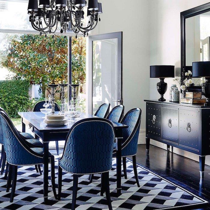 črna, siva in bela preproga v vintage jedilnici, modra miza in stoli, modra komoda, eleganten lestenec