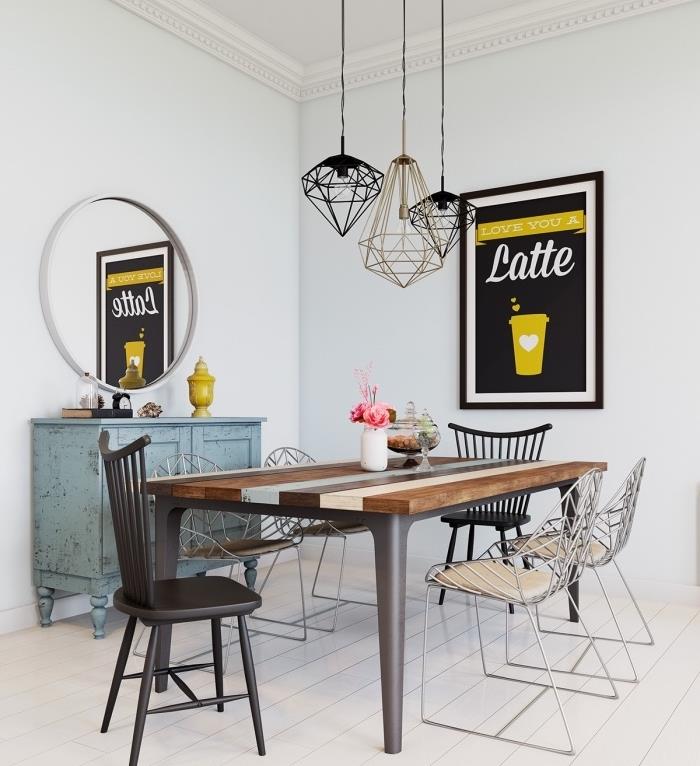 İskandinav evinde yemek odası dekoru, ahşap masa, ahşap ve metal sandalyeler, patinalı mavi şifonyer, grafik ve sarı duvar dekoru, orijinal askılar