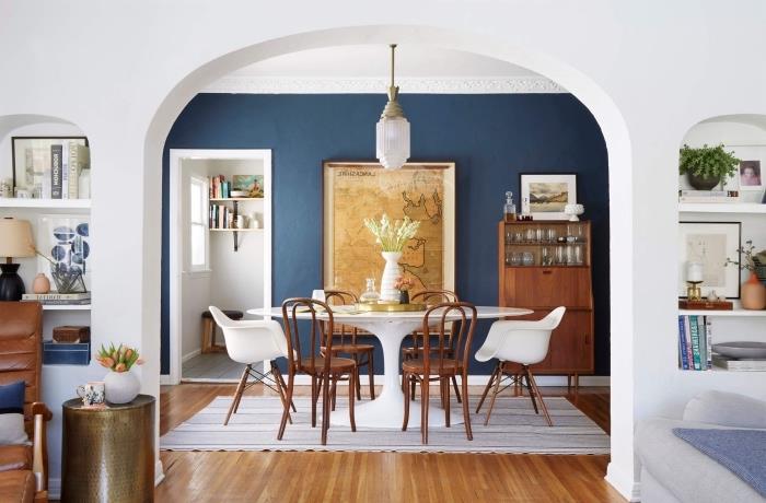 Dinlendirici ve dengeli bir atmosfer için mavi ve beyaz yemek odası bulunan oturma odası, mekana derinlik katan lacivert arka plan