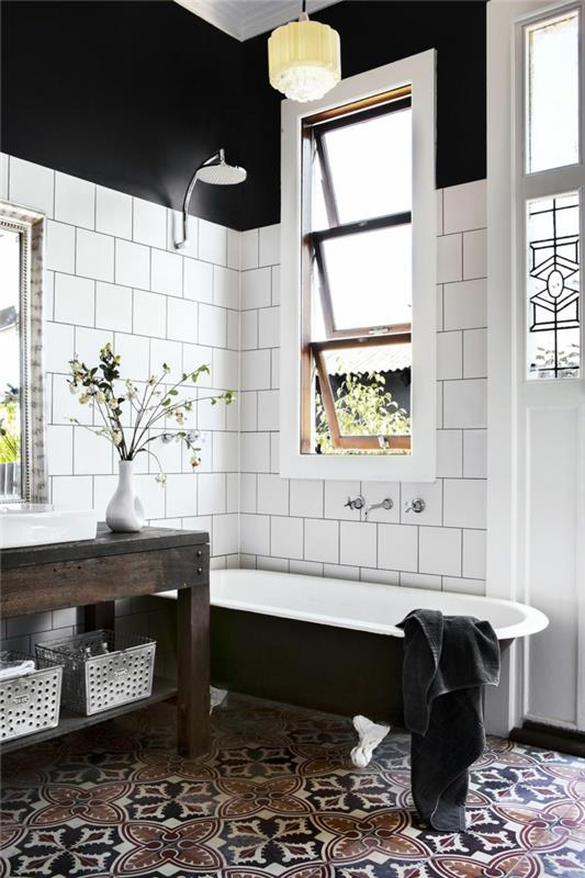 siyah beyaz banyo dekoru, siyah beyaz dökme demir küvet, beyaz fayans ve çimento karo zemin; siyah duvarlar